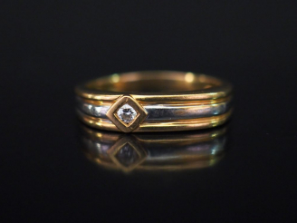Vente aux enchères Bague de forme stylisée trois tons d'or, sertie d'un petit diamant.  T