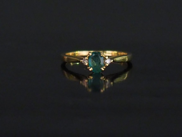 Petite bague en or jaune, sertie en son centre d'une émeraude épaulée 
