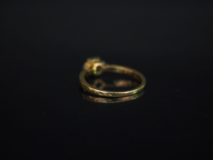 Petite bague en or jaune, sertie en son centre d'une émeraude épaulée 