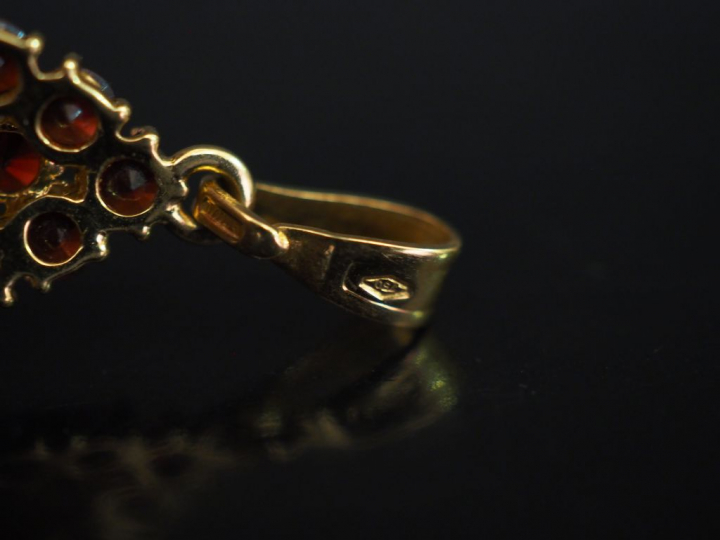 Pendentif de forme ovale en or jaune, serti de grenats. H. 2 cm Poids 