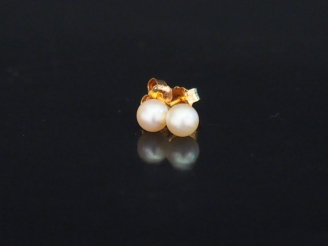 Vente aux enchères Paire de puces d'oreilles en or jaune et perle blanche. Diam. 4 mm env