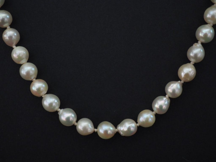 Collier de perles blanches de forme baroques.  Fermoir en or jaune.  C