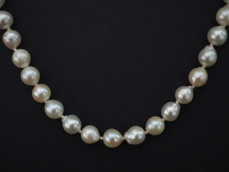 Vente aux enchères Collier de perles blanches de forme baroques.  Fermoir en or jaune.  C