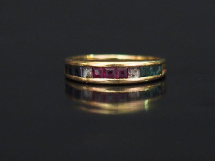 Demi-alliance en or jaune, sertie de pierres de couleur calibrées.  TD