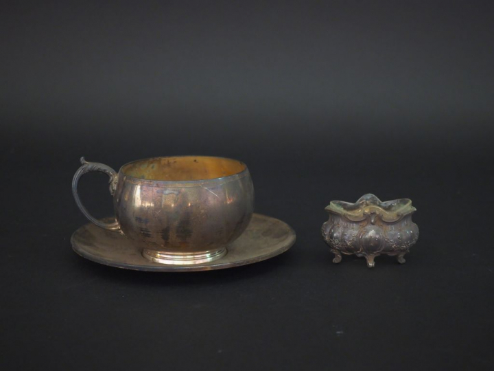 Tasse et sa sous-tasse en argent, poinçon Minerve.  Anse feuillagée.  