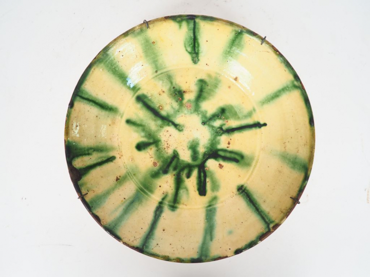 Coupe sur talon XIXème en terre vernissée à décor mêlé vert et jaune. 