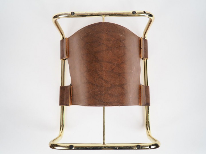 Porte revues en métal doré et cuir. Dim. 22,5 x 36 x 42,5 cm.