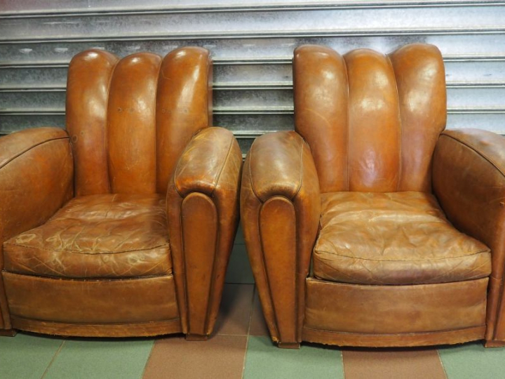 Paire de fauteuils club en cuir brun. (usures)
