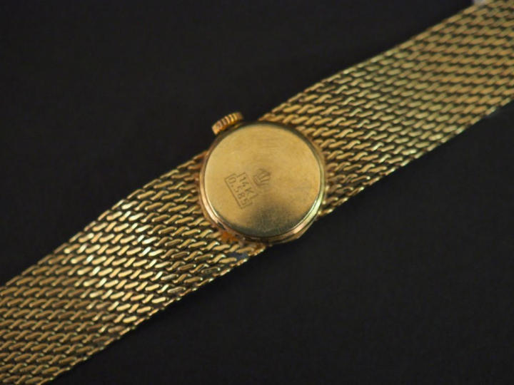 Montre bracelet de dame, boitier et bracelet en or jaune 14k. Caran ro