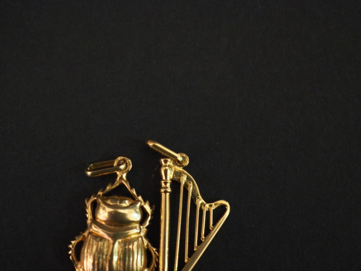 Ensemble comprenant :  - un pendentif en or jaune, en forme de harpe. 