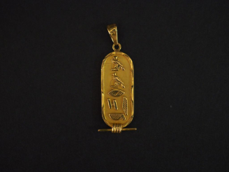 Vente aux enchères Pendentif de style égyptien en or jaune, à décor de hiéroglyphes.  H. 