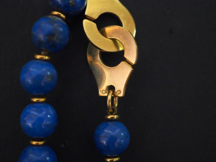 Collier de perles de lapis lazuli, fermoir menotte en or jaune. Long. 