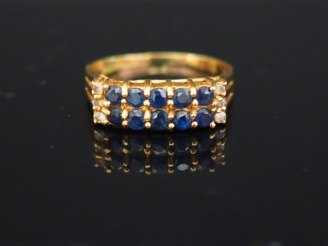 Vente aux enchères Bague pont en or jaune, sertie de deux lignes de pierres bleues et de 