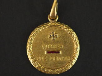 Vente aux enchères Médaille en or jaune, éclats de diamants et pierres roses marquée "+ q