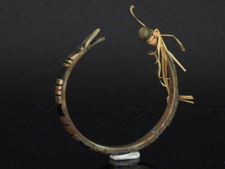 Bracelet en métal figurant un serpent, rehaussé d'émail noir et rouge.