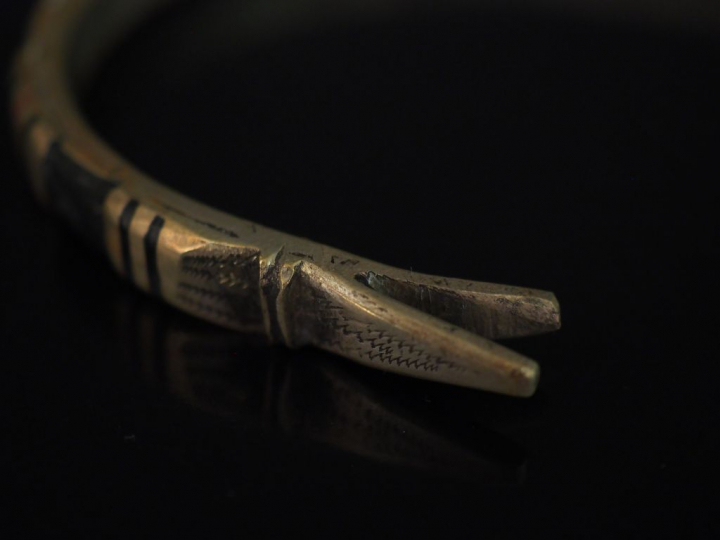 Bracelet en métal figurant un serpent, rehaussé d'émail noir et rouge.