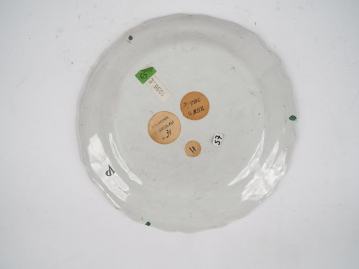 MARSEILLE.  Assiette en faïence de petit-feu à décor d’un jeté de fleu