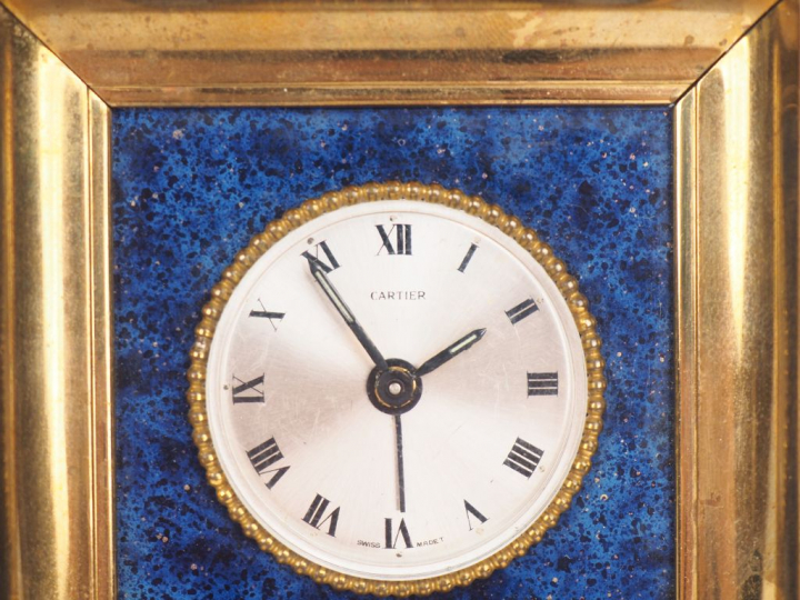 CARTIER. Réveil en laiton et Lapis-lazuli à décor d'une frise de perle