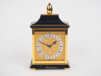 Vente aux enchères LUXOR. Pendulette de table en laiton, cadran à décor de rinceaux. Sign