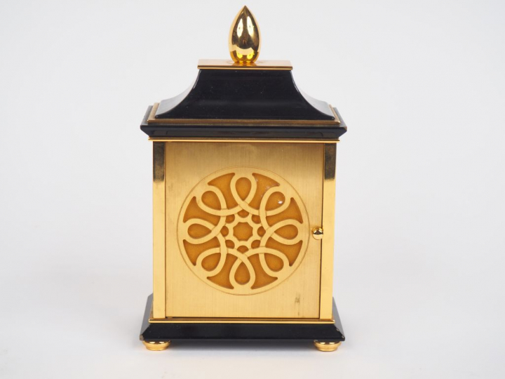 LUXOR. Pendulette de table en laiton, cadran à décor de rinceaux. Sign