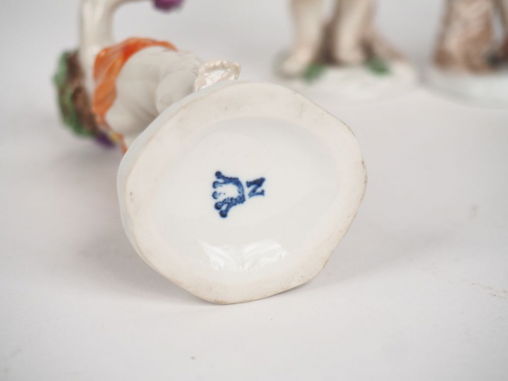 4 sujets en porcelaine polychrome "amours". Marqués sous la base. H. 1