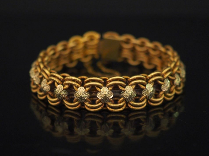 Bracelet en or deux tons, maille ajourée à décor d'entrelacs et de feu