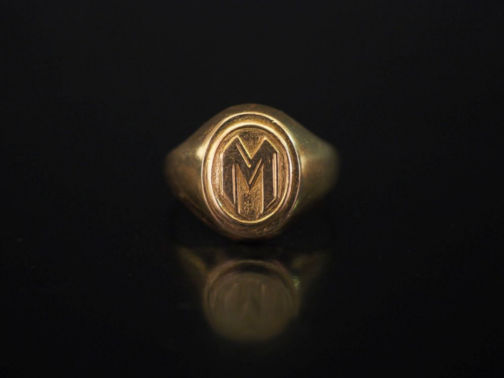 Bague de forme chevalière en or jaune, à décor de la lettre "M". TDD. 