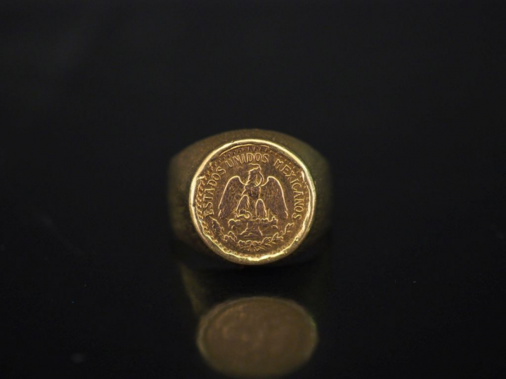 Bague en or jaune, sertie en son centre d'une pièce de deux Pesos.  TD