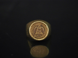 Vente aux enchères Bague en or jaune, sertie en son centre d'une pièce de deux Pesos.  TD