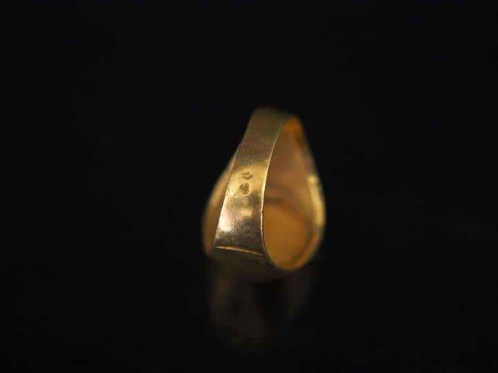 Bague en or jaune, sertie en son centre d'une pièce de deux Pesos.  TD