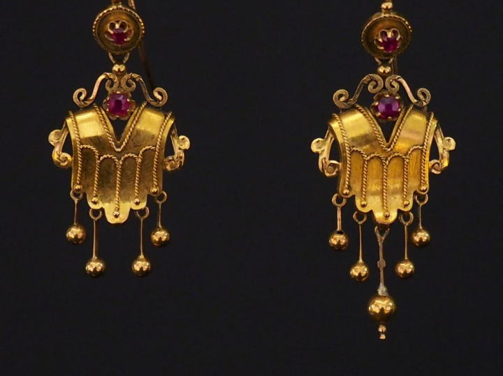 Paire de perce oreilles de style antique en or et pierres rouges. Dans