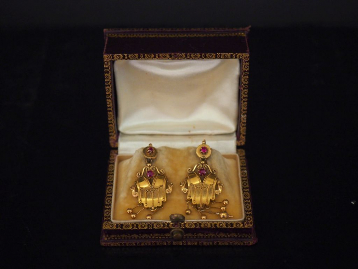 Paire de perce oreilles de style antique en or et pierres rouges. Dans