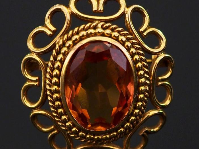 Broche en or et topaze, monture à décor d'entrelacs. Poids tel : 8,30 