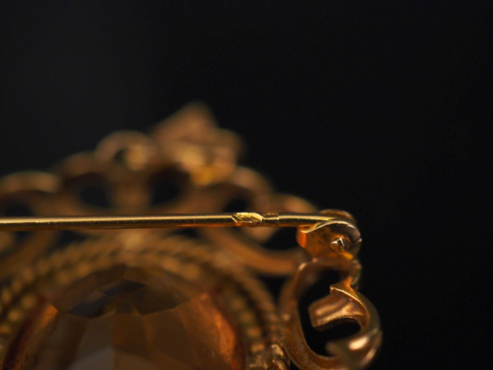 Broche en or et topaze, monture à décor d'entrelacs. Poids tel : 8,30 