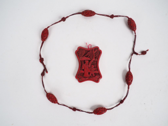 Vente aux enchères Lot composé d'un pendentif en laque de Cinabre et un  mala. Chine débu