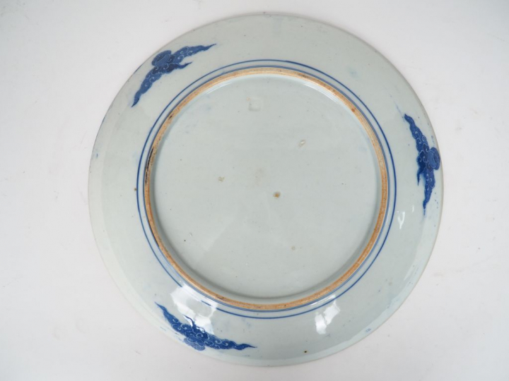 Plat en porcelaine à décor au pochoir en camaïeu de bleu d'un paysage 