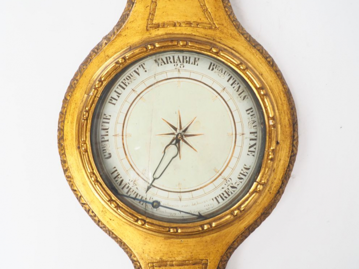 Baromètre Louis XVI en bois sculpté et doré à décor de nœud de ruban. 