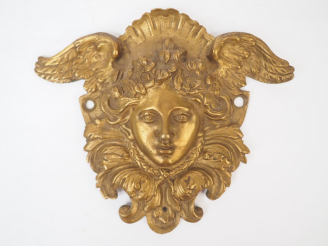 Vente aux enchères Bronze d’ameublement XIXème figurant un visage de jeune femme ailée. D