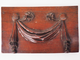 Vente aux enchères Plaque en acajou sculpté à décor de draperie. Dim. 11,8 x 19,5 cm.