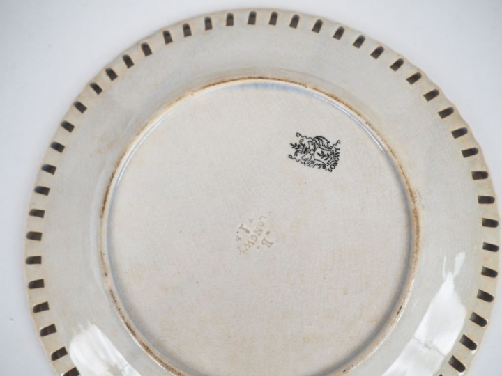 Manufacture de LONGWY. 7 assiettes en faïence ajourée à décor en grisa