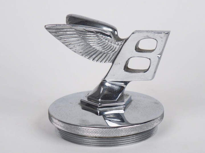 Mascotte automobile Bentley en métal argenté. Dim. 9 x 10 x 9 cm.