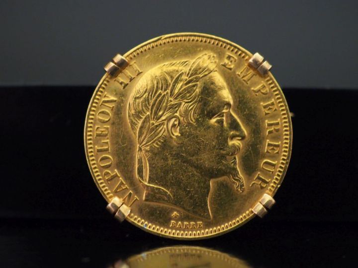 Broche en or jaune, sertie en son centre d'une pièce de 50 Francs or. 