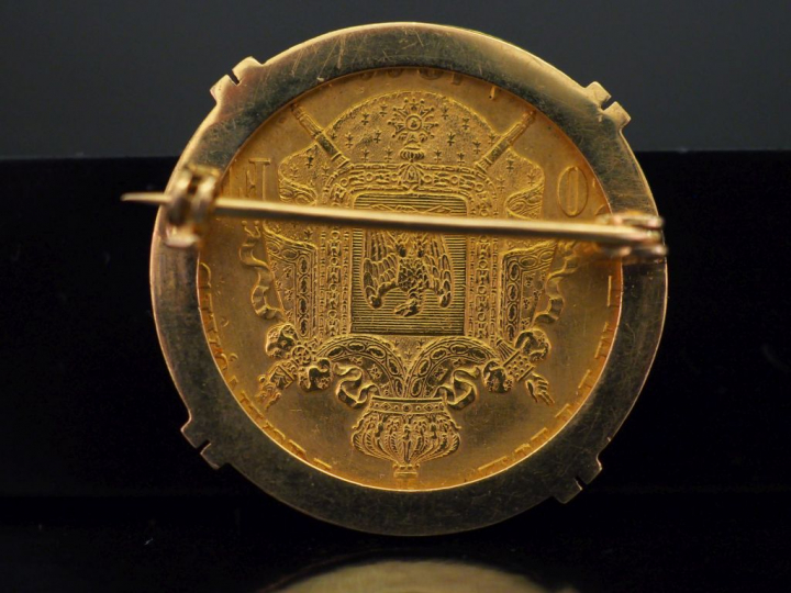 Broche en or jaune, sertie en son centre d'une pièce de 50 Francs or. 