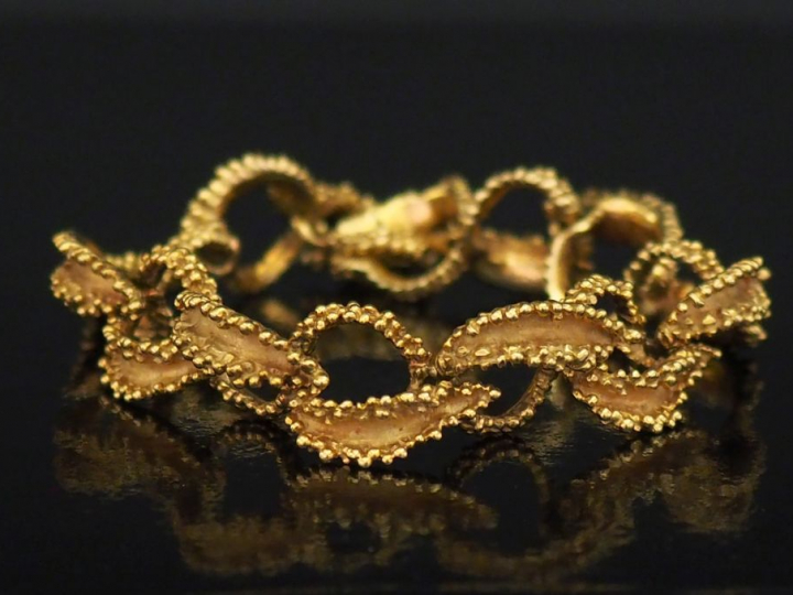 Bracelet articulé en or jaune, à décor ajouré d'entrelacs.  Long. 19 c
