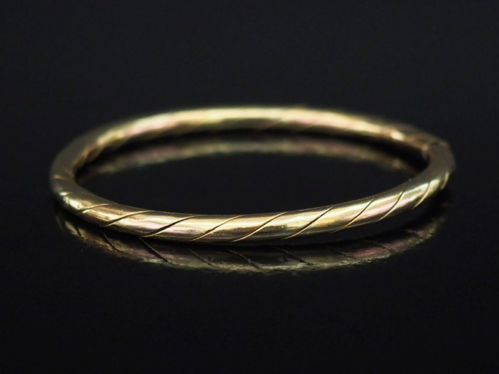 Bracelet jonc en or jaune, à décor gravé de côtes torses.  Fermoir lat