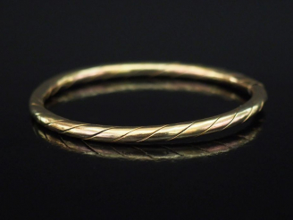 Vente aux enchères Bracelet jonc en or jaune, à décor gravé de côtes torses.  Fermoir lat