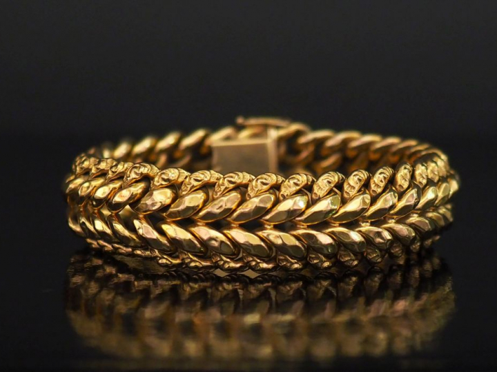 Bracelet manchette articulé en or jaune, maille plate.  Long. 19,5 cm 