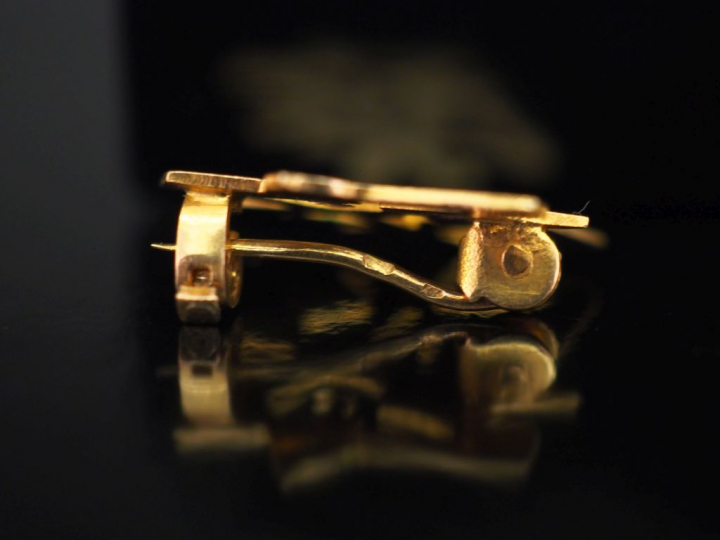 Petite broche en or jaune en forme de caractère.  1,9 x 2,1 cm Poids. 