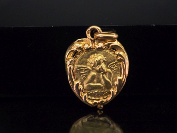 Médaille en or jaune, à décor en son centre d'un angelot. Le pourtour,