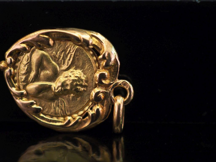 Médaille en or jaune, à décor en son centre d'un angelot. Le pourtour,